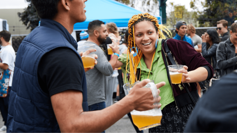 Festival attendees dance while holding beer